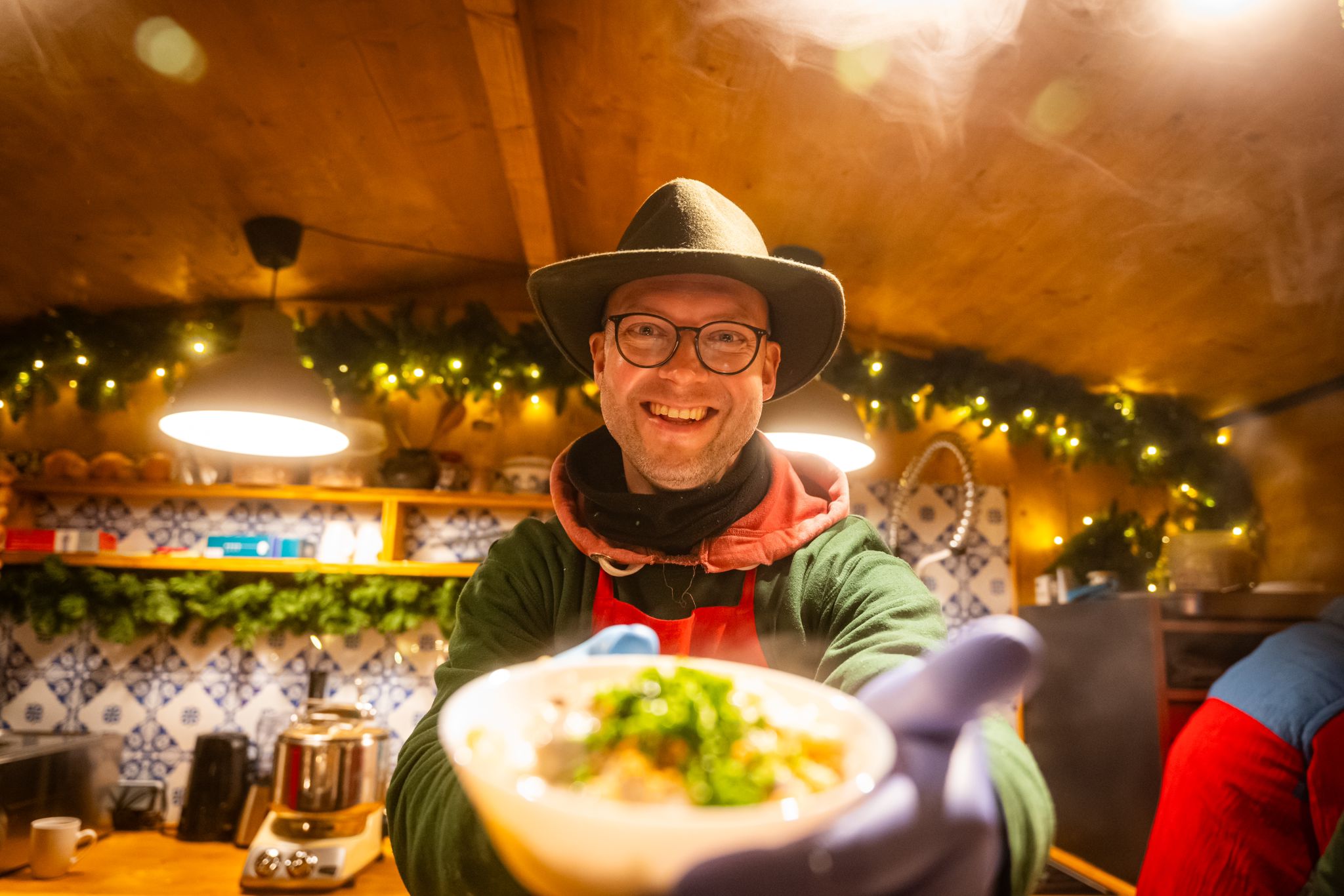 Käsespätzle werden frisch an einen Gast ausgegeben